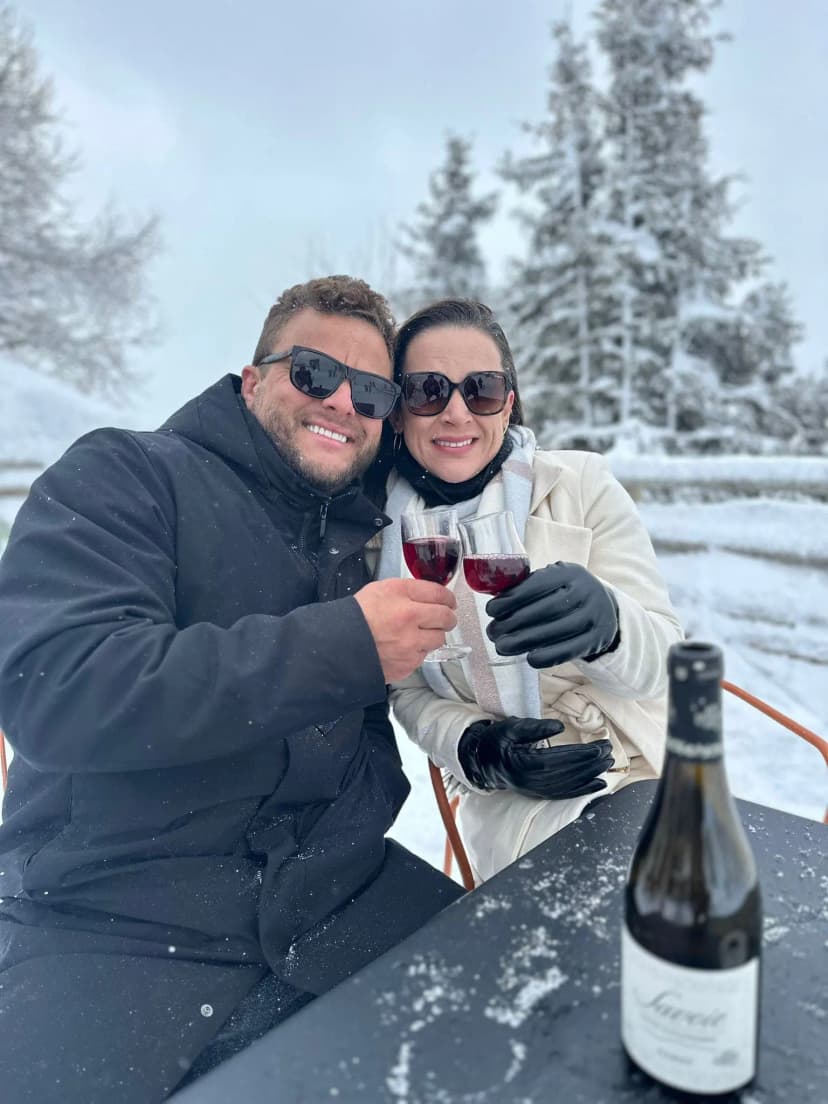 Casal Renato e Dalila segurando uma taça de vinho e sorrindo