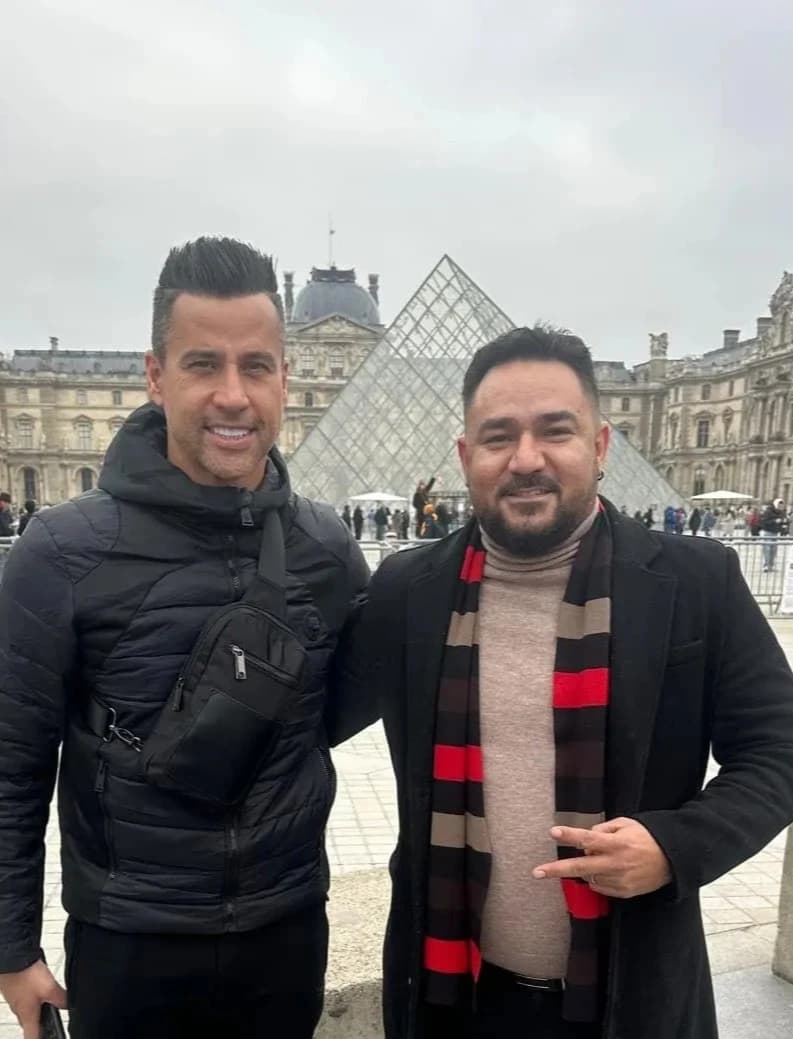 Jogador Fabio e o motorista Irval sorrindo durante o passeio em frente o louvre